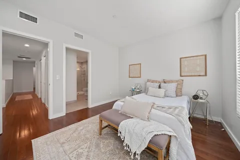 a bedroom with a bed and wooden floor