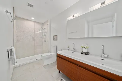 a bathroom with a sink a toilet and shower
