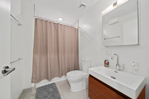 a bathroom with a sink toilet and mirror