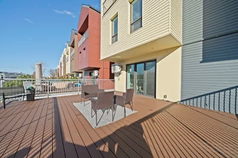 a view of a roof deck with table and chairs wooden floor and fence