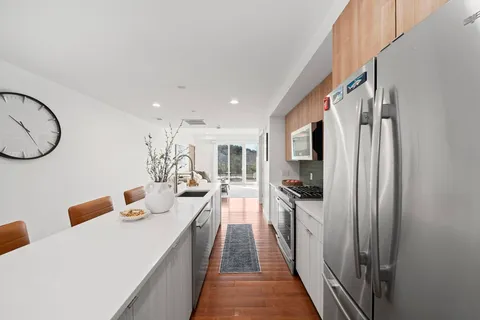 a dining room with stainless steel appliances granite countertop a refrigerator and a sink