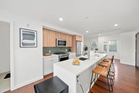a kitchen with a dining table chairs and refrigerator