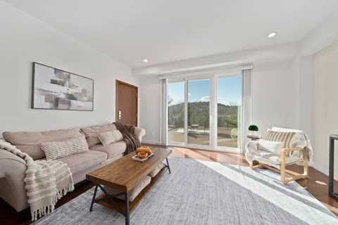 a living room with furniture and a floor to ceiling window