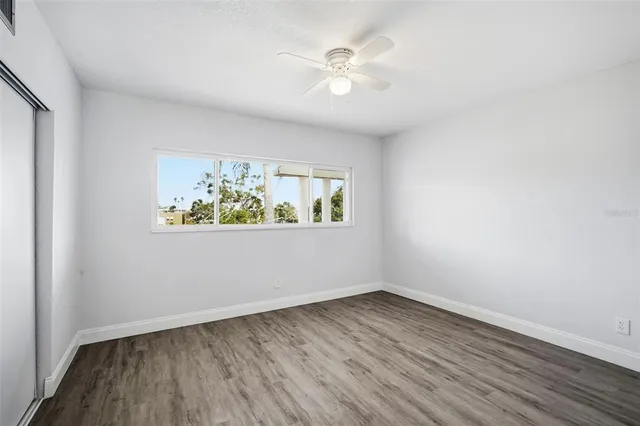 an empty room with wooden floor and window