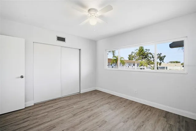 an empty room with wooden floor and window