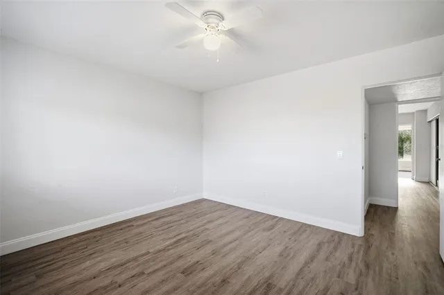 a view of a room with wooden floor and a ceiling fan