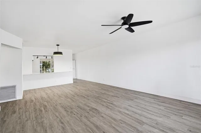 a view of empty room with wooden floor and window