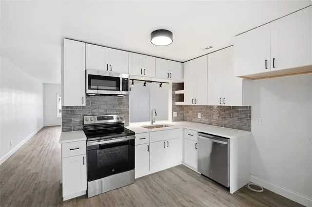 a kitchen with a stove a sink and a refrigerator