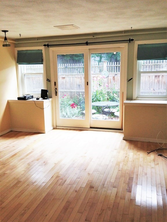 110 Maple Place, Unit 7 Dedham, MA 02026 - Photo 4 of 17 an empty room with wooden floor and windows