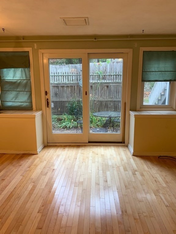 110 Maple Place, Unit 7 Dedham, MA 02026 - Photo 5 of 17 an empty room with wooden floor and windows