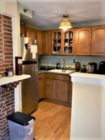 110 Maple Place, Unit 7 Dedham, MA 02026 - Photo 8 of 17 a kitchen with a sink cabinets and window