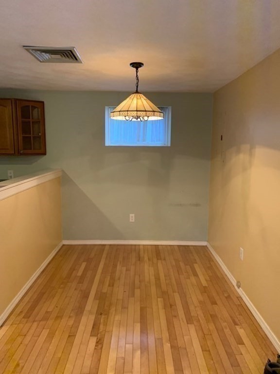 110 Maple Place, Unit 7 Dedham, MA 02026 - Photo 10 of 17 a view of a room with wooden floor a ceiling fan and a rug
