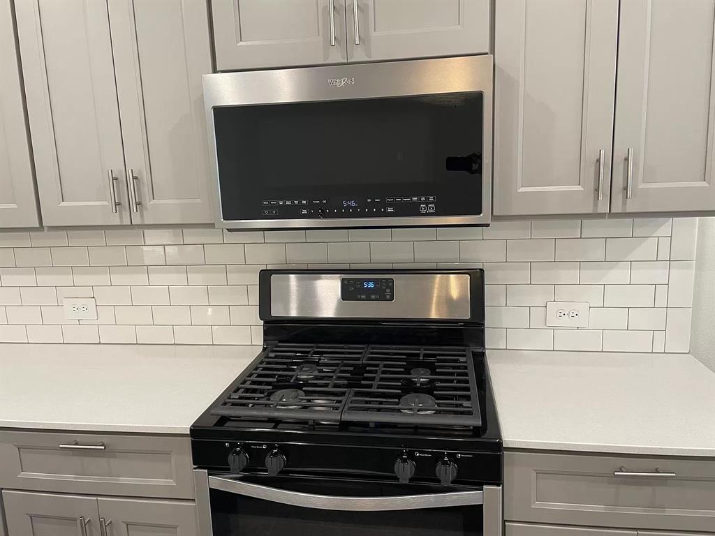 1752 Redding Street Allen, TX 75002 - Photo 8 of 24 Kitchen featuring appliances with stainless steel finishes, decorative backsplash, and gray cabinetry