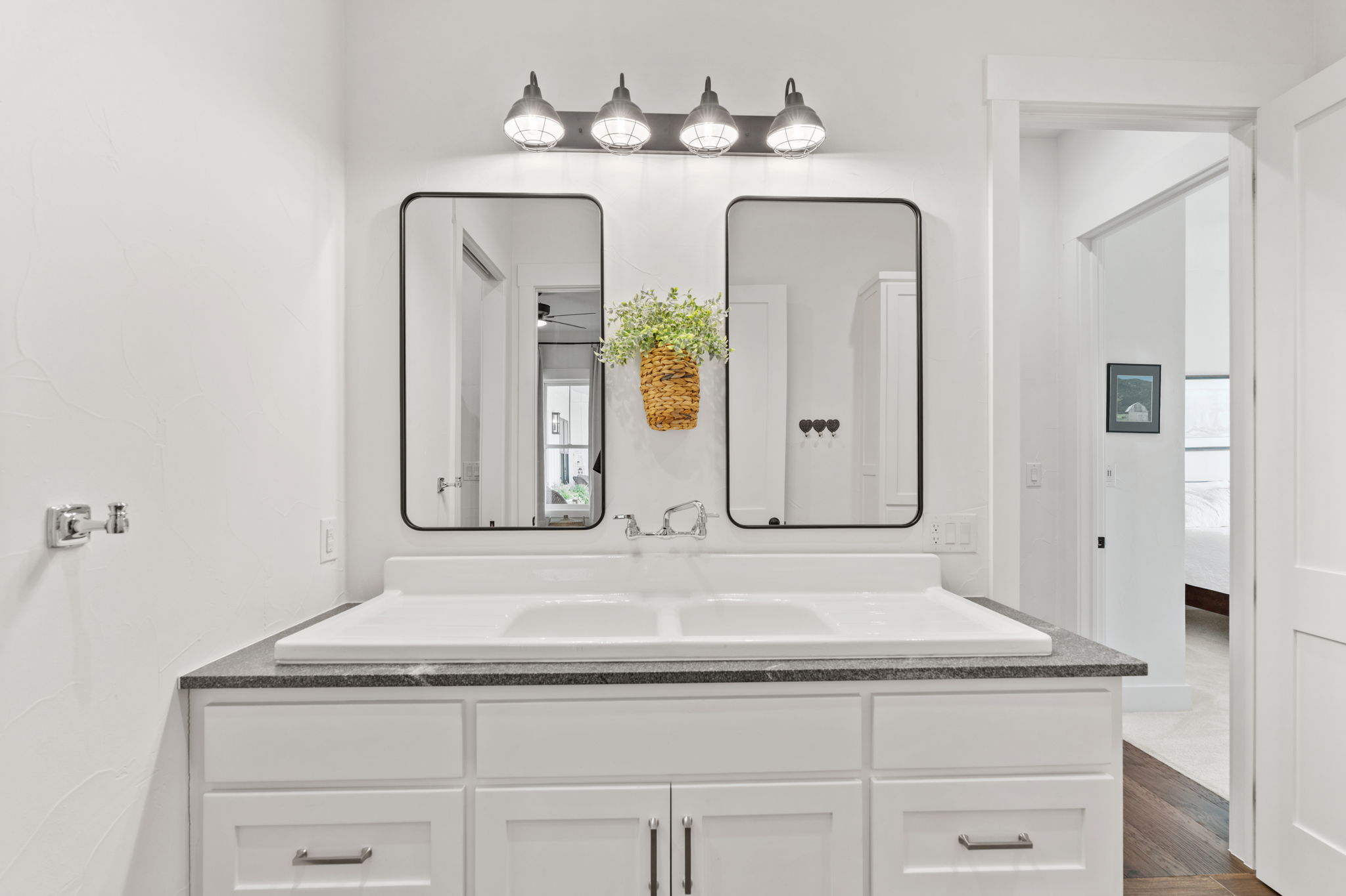 452 Southwick Ranch Road Johnson City, TX 78636 - Photo 23 of 40 A well-lit primary bathroom features a double vanity and sleek mirrors, offering a clean, contemporary design.