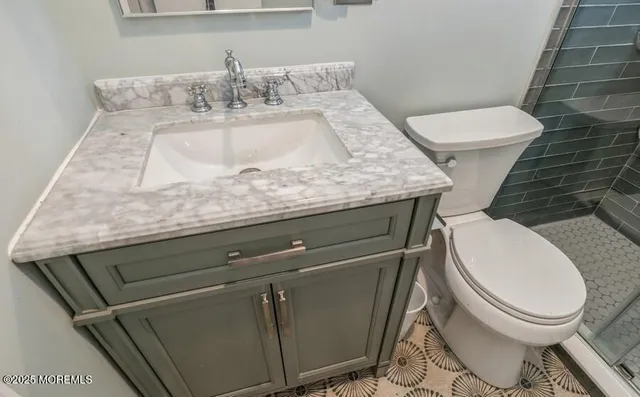 a bathroom with a granite countertop toilet sink and mirror