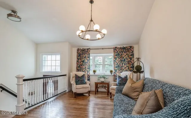 a living room with furniture chandelier and a window