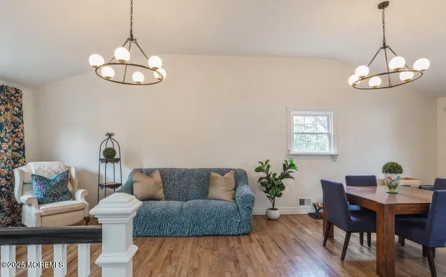 a living room with furniture wooden floor and chandelier