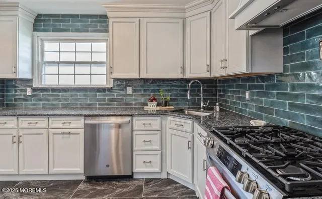 a kitchen with white cabinets and appliances