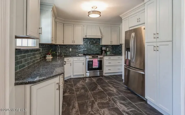 a kitchen with stainless steel appliances granite countertop a refrigerator stove and sink