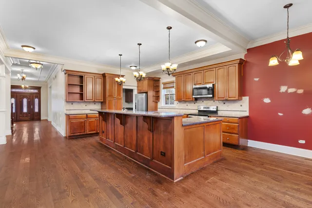 a kitchen with stainless steel appliances granite countertop a sink a stove and a refrigerator