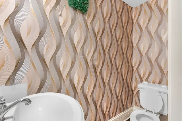 an empty room with windows fireplace and a chandelier fan