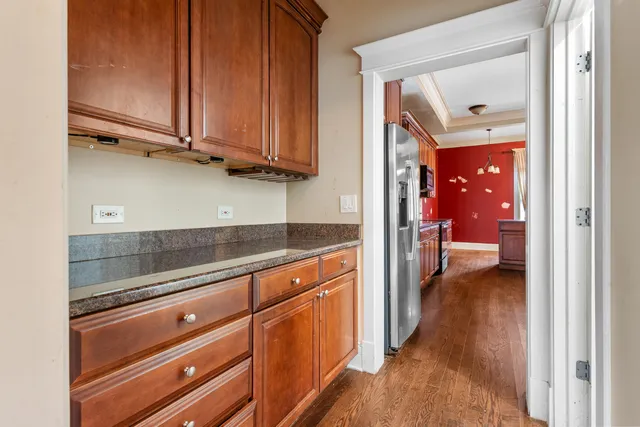 a large kitchen with stainless steel appliances granite countertop wooden cabinets a oven and a large window