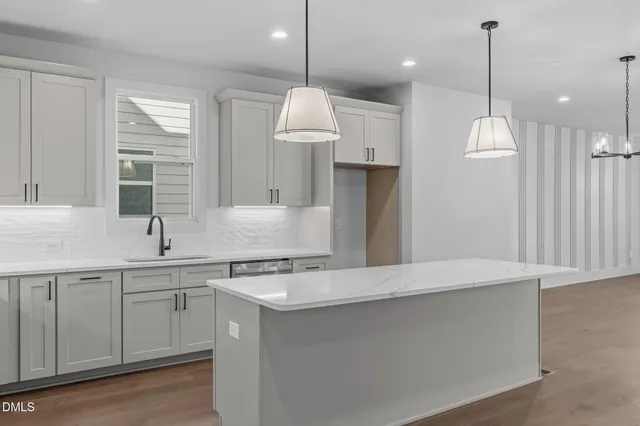 a kitchen with a sink chandelier and refrigerator