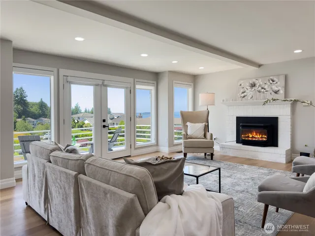 a living room with furniture large window and a fireplace