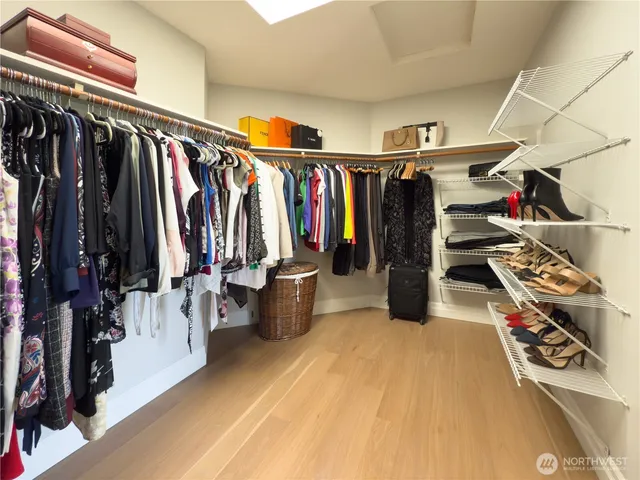 a view of walk in closet with clothes and shoes