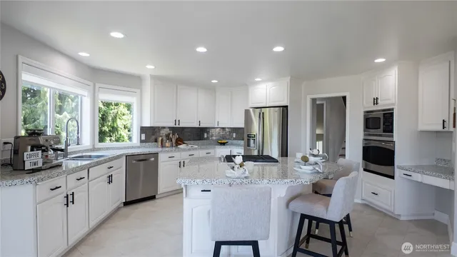 a kitchen with stainless steel appliances kitchen island granite countertop a sink and cabinets