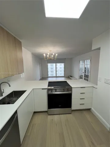a large kitchen with granite countertop a stove and a sink
