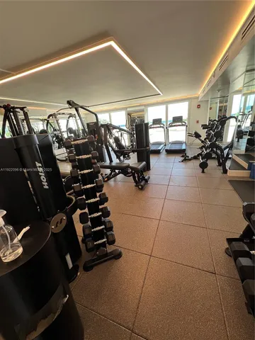a gym room with lots of chairs and mirrors