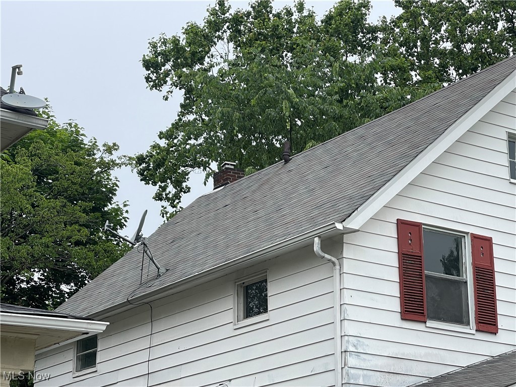 912 Yellowstone Road Cleveland Heights, OH 44121 - Photo 5 of 35 Exterior view of gutters, a downspout, a chimney, and roof with shingles