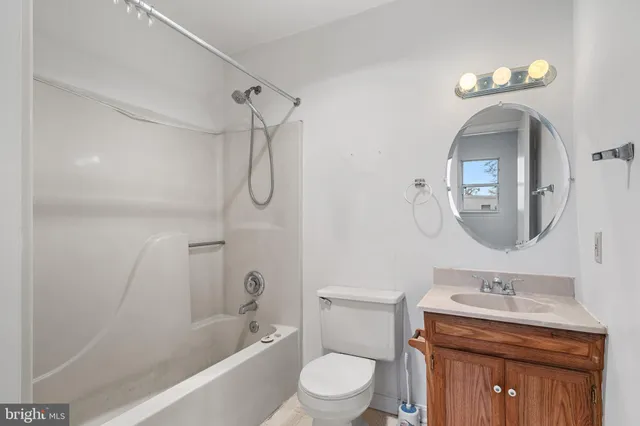 a bathroom with a toilet sink vanity tub and shower