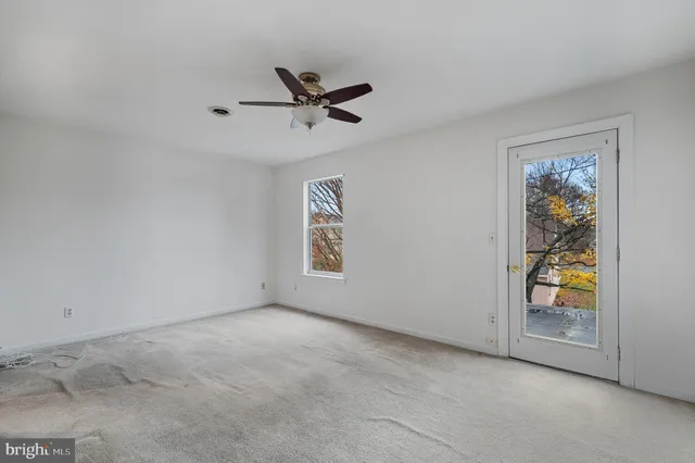 an empty room with window and ceiling fan view