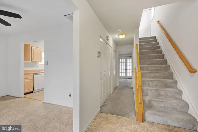a view of a hallway to an entryway with staircase