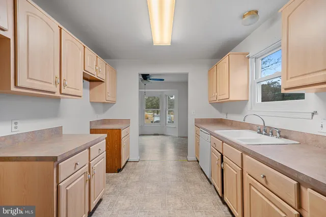 a kitchen with granite countertop a sink stove and cabinets