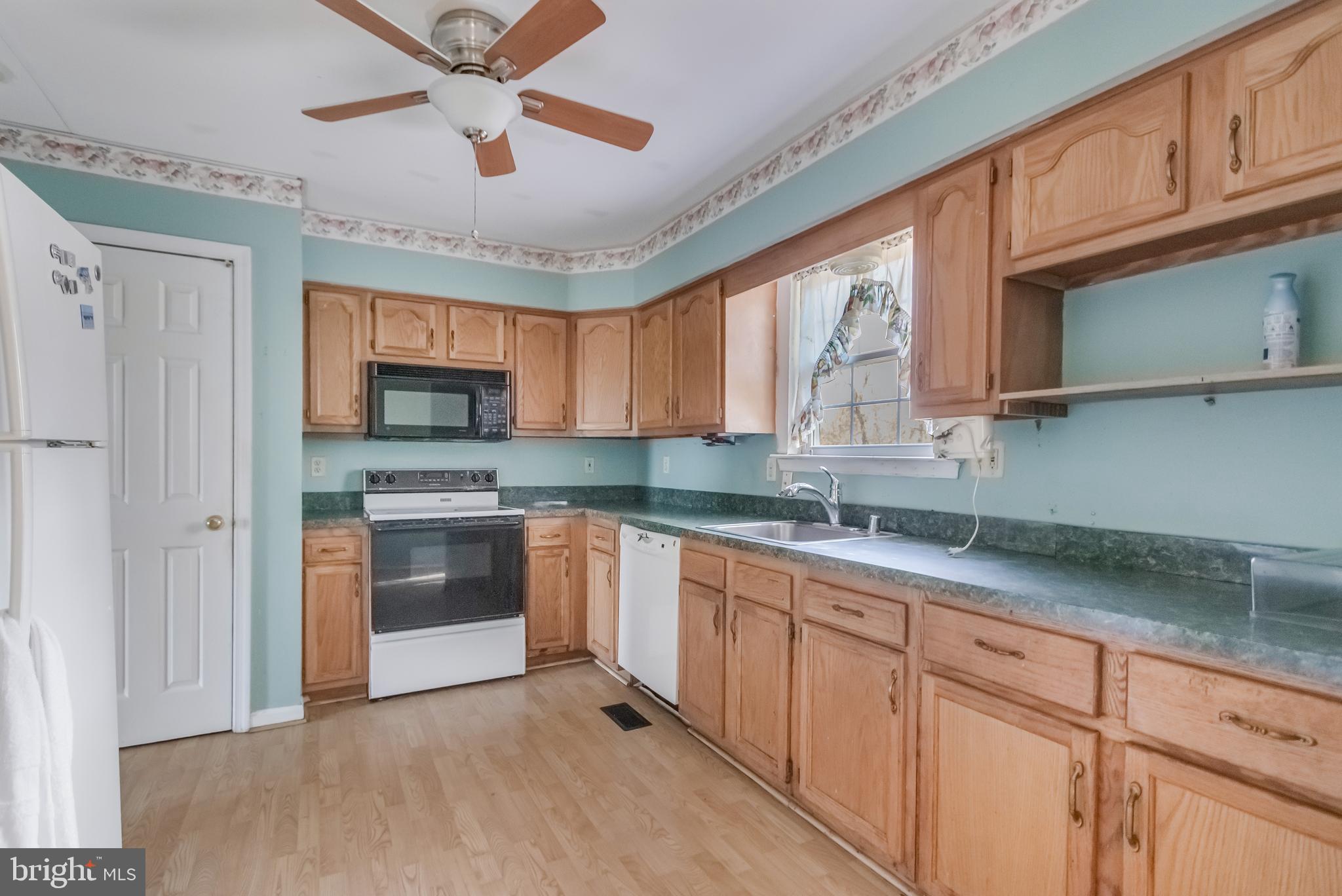 1104 Saffron Way Owings, MD 20736 - Photo 7 of 26 a kitchen with stainless steel appliances granite countertop a stove sink and cabinets