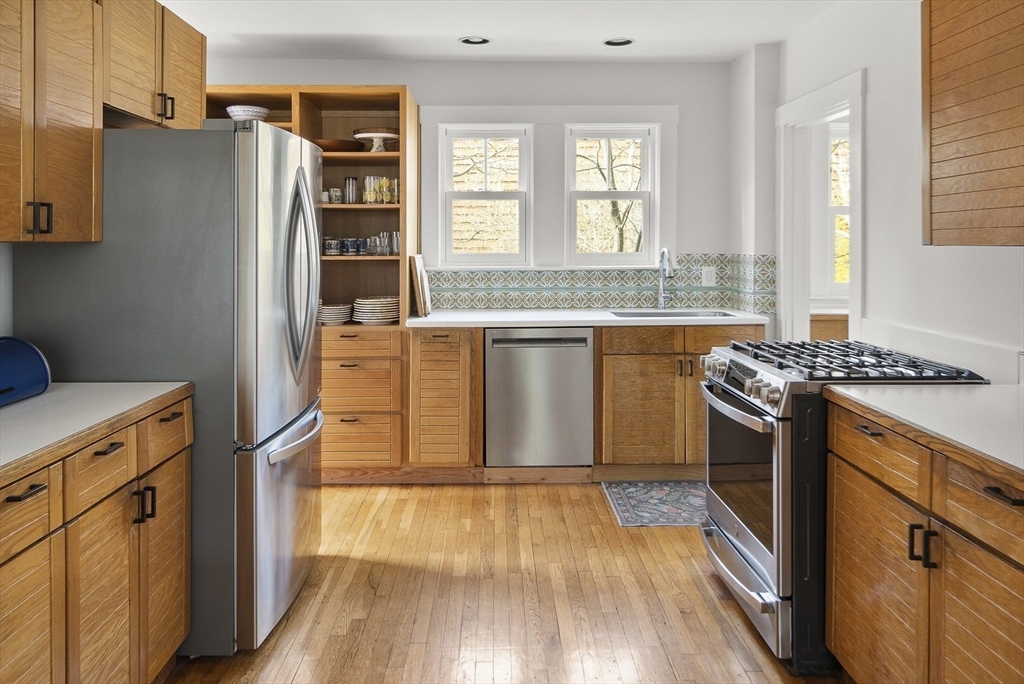 40 Eustis Street Cambridge, MA 02140 - Photo 4 of 23 a kitchen with stainless steel appliances granite countertop a refrigerator a stove and a wooden floors