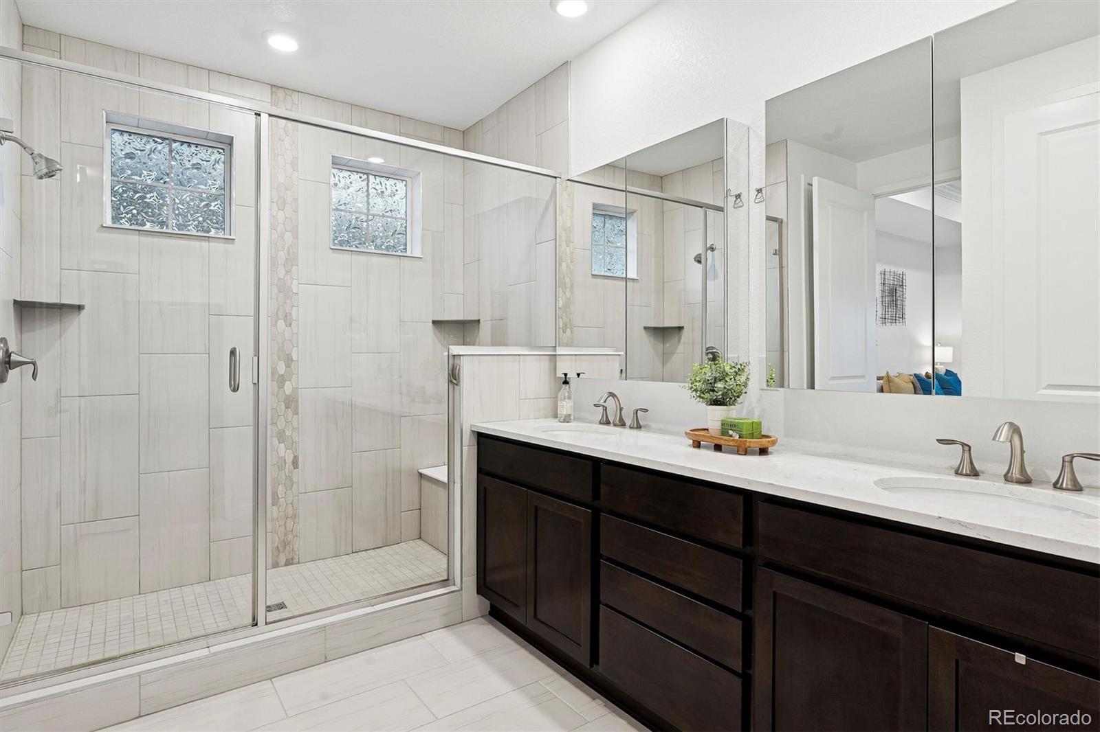 8500 South Riviera Court Aurora, CO 80016 - Photo 19 of 35 a bathroom with a double vanity sink mirror and shower