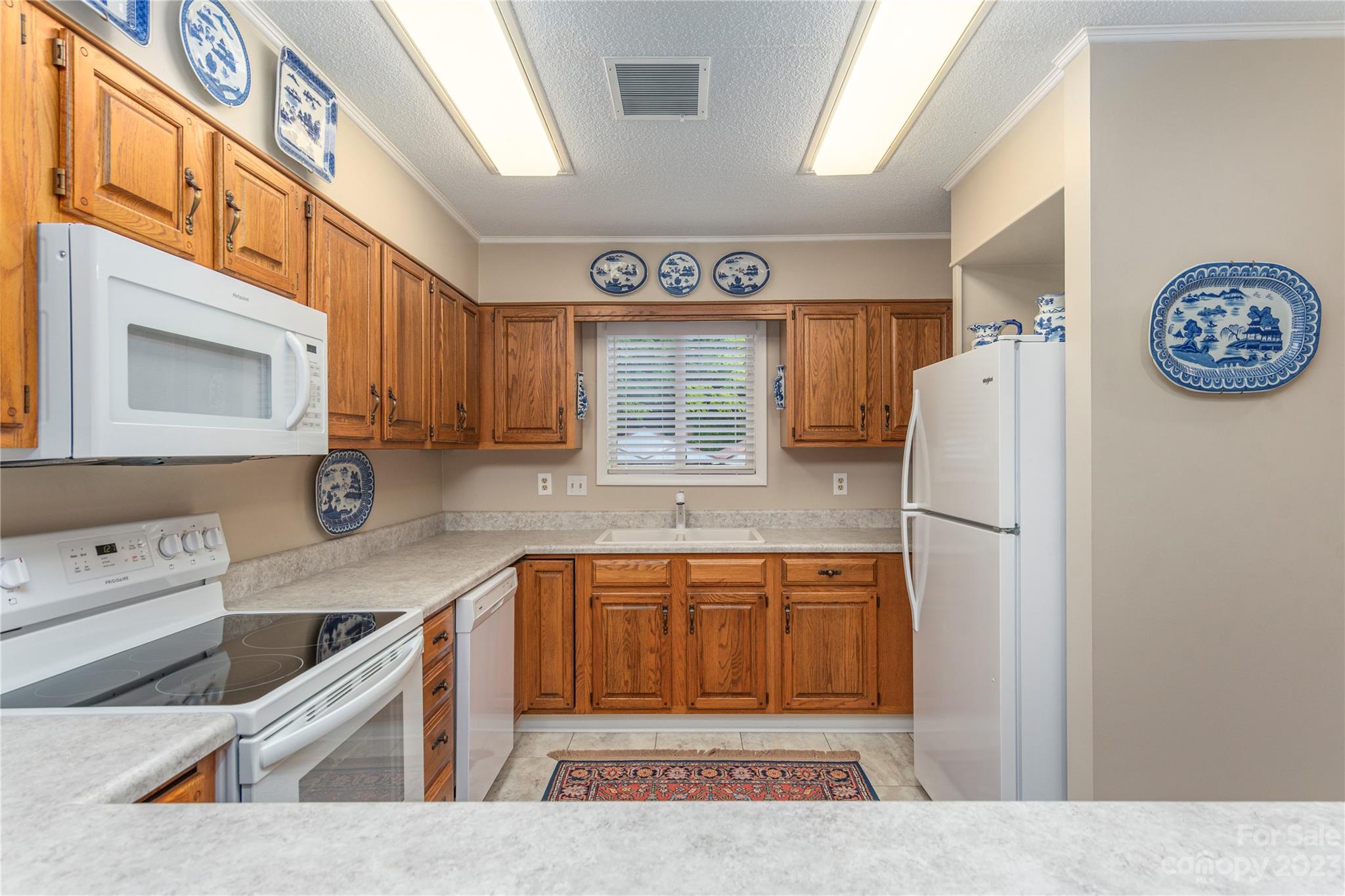 87 Willow Road, Unit D12 Waynesville, NC 28786 - Photo 12 of 21 a kitchen with stainless steel appliances granite countertop a refrigerator and a sink