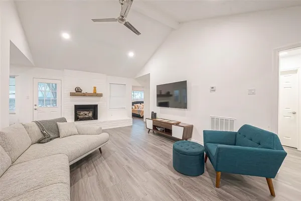 a living room with furniture a flat screen tv and a fireplace