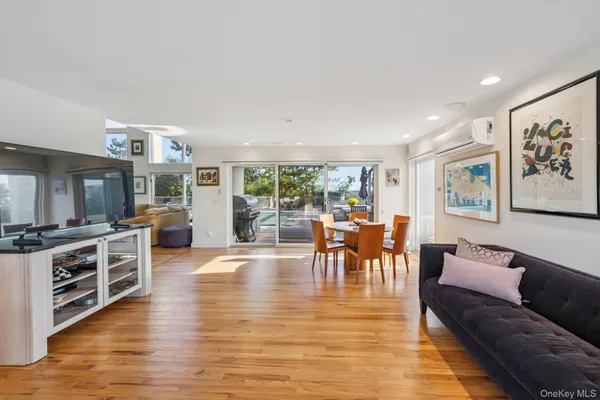 a dining room with furniture a kitchen view and wooden floor