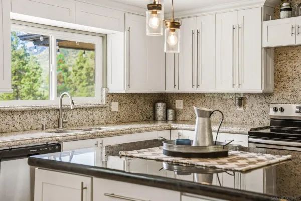 a kitchen with granite countertop a sink stainless steel appliances and cabinets