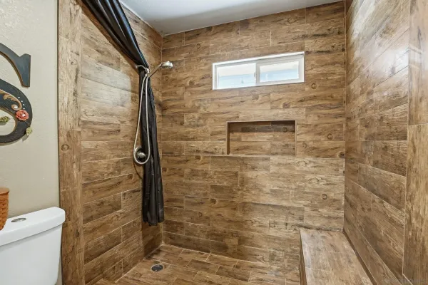 a bathroom with a toilet and a shower