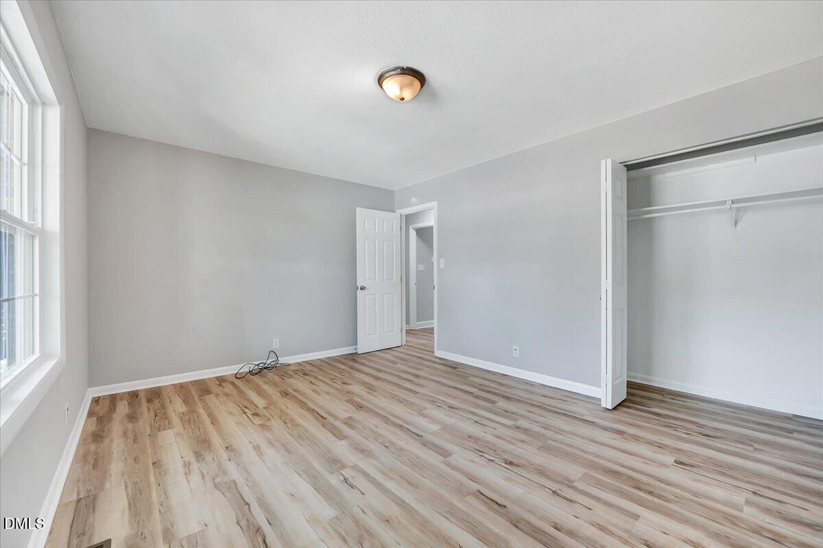 3408 Atlantic Avenue Raleigh, NC 27604 - Photo 10 of 48 a view of an empty room with wooden floor and a window