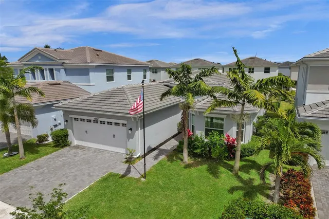 a front view of a house with a yard and potted plants