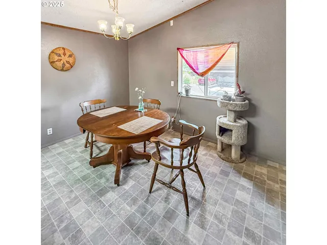 a view of a room that has a table and a chair in it