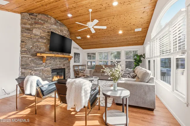 a living room with furniture a flat screen tv and a floor to ceiling window