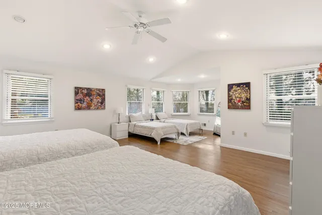 a spacious bedroom with a bed and wooden floor